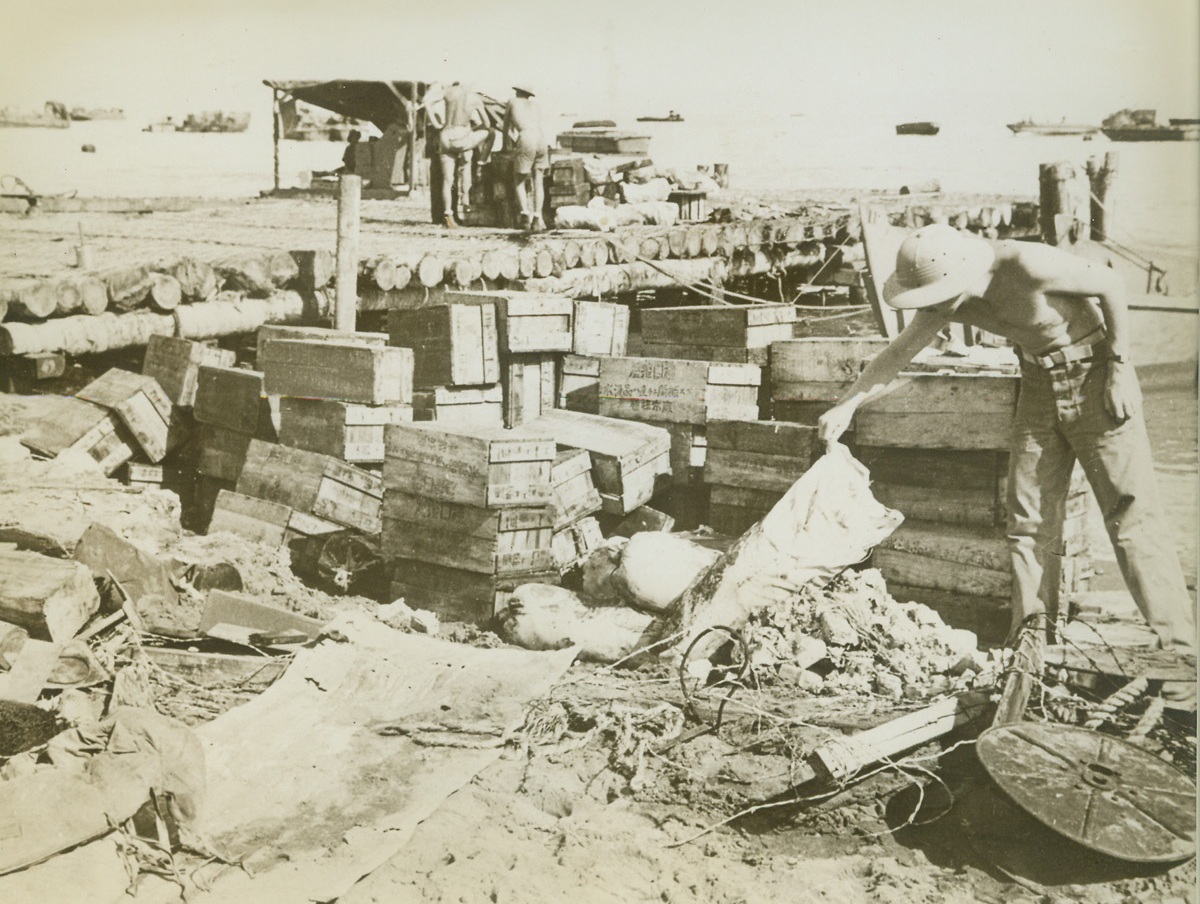 Right Street - - Wrong House, 2/5/1943. Guadalcanal – A U.S. soldier curiously inspects a bag of food among the Jap provisions thrown overboard by enemy destroyers and picked up by our ships off Guadalcanl.  The Nips have had a difficult time supplying their hard-pressed fighters on the South Pacific island.Credit Line (ACME);