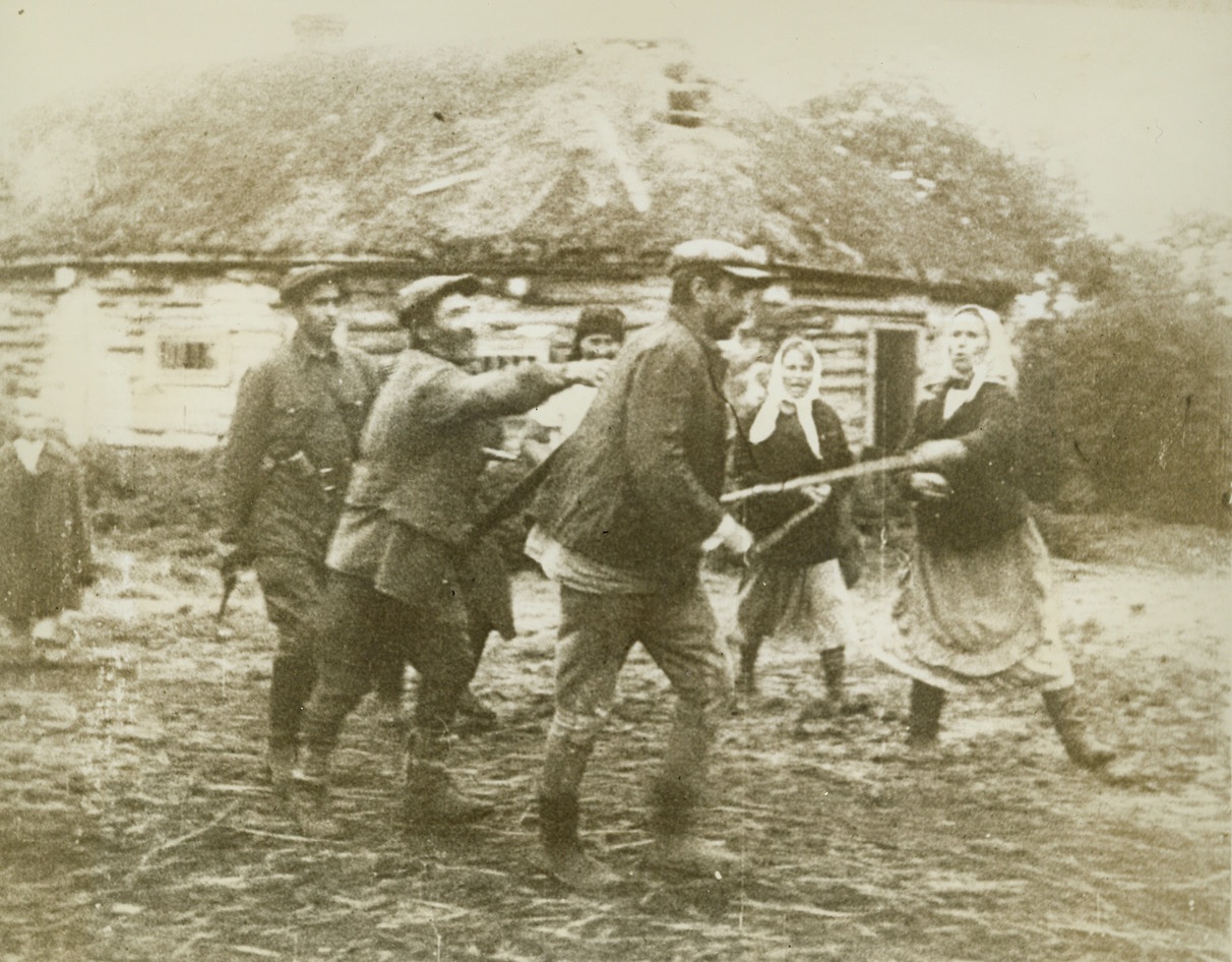 Russian Quisling, 2/10/1943. On the Russian Front—Like every other people fighting for freedom, the Russians despise those among their ranks who turn traitor and give aid to the invaders. Here a Russian “quisling” is made the object of jeers and poking sticks from Soviet villagers. Photo is from the March of Time documentary film, “One Day of War—Russia, 1943,” which depicts the action along the vast Russian front in a single day. Passed by censors. Credit: Copyright March of Time photo from ACME.;