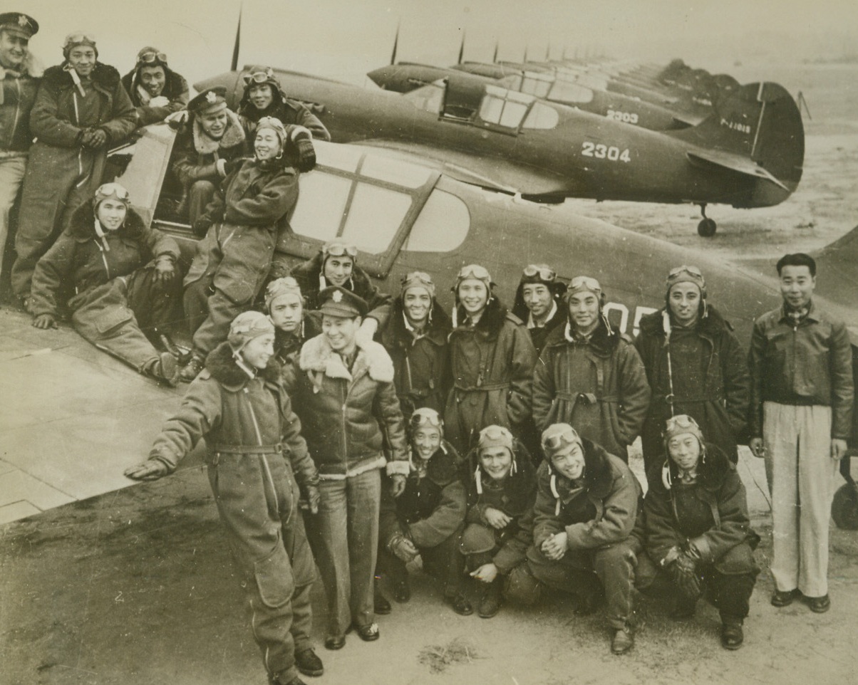 FIGHTERS FOR THE SKIES OF CHINA, 3/10/1943. CHENGTU, CHINA—This smiling group of Chinese fighter pilots don’t seem to be worried about the prospect of another brush with the Japs. As they pose near one of the a long line of their American-built pursuit planes, near Chengtu. They have all been trained in the U.S. and are veterans of many a dogfight with the Nips. In cockpit of ship, and standing at far left on wing, are two American fliers.  Credit: ACME.;