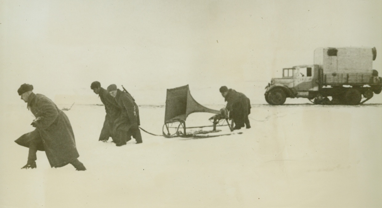 A Word to the Wise—, 3/2/1943. NORTH RUSSIAN FRONT—Red Army men drag a large loudspeaker mounted on runners into position for a “verbal” attack on Nazi outposts along the Northern front. Using powerful amplifiers, the Russians keep the Germans informed of the progress of the fighting in Russia—recently all in favor of the Red. Passed by censors.Credit: ACME;