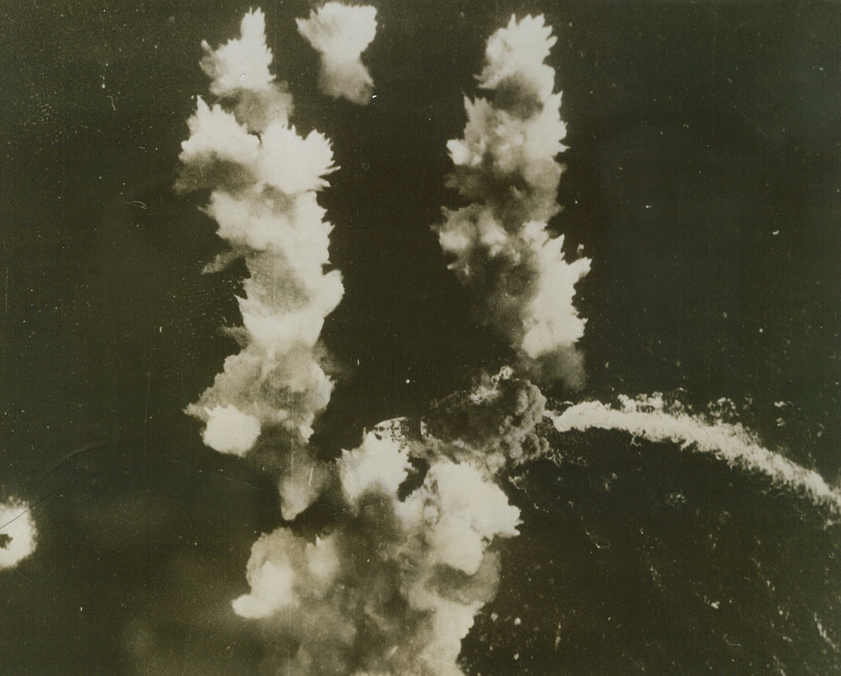 DIRECT HIT ON ITALIAN LINER, 5/26/1943. A Flying Fortress has just registered a direct hit on this huge Italian Liner, converted to carry troops, and smoke almost completely hides the vessel in this photo released in Washington today. Vessel’s wake, (at right, in photo) shows it was trying to swing in a wide circle to avoid bomb hits from the plane, which was attached to the Northwest African Strategic Air Force operating in the Mediterranean area. Credit Line (U.S. Army Air Forces Photo from ACME);