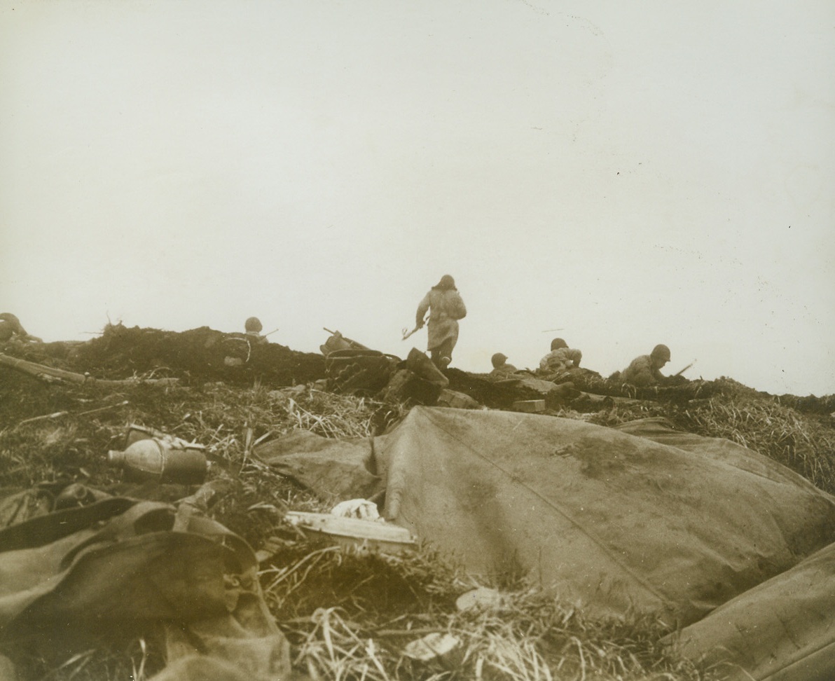 First Photos of Yank Landing on Attu, 5/26/1943. Washington, D.C.- - This photo, one of the first taken of the landing of U.S. troops on Jap-held island last May 11th, was taken by a Navy combat photographer and released in Washington today.  Cameramen who took these photos of the landing at two points on the island, Massacre Bay and Holtz Bay, were under Jap fire many times.  Here, U.S. troops advance in the face of enemy fire.  This is a front line shot made just as a bank of fog came rolling in.  While this photo was taken, Jap bullets were singing by.Credit Line (U.S. Navy photo from ACME);