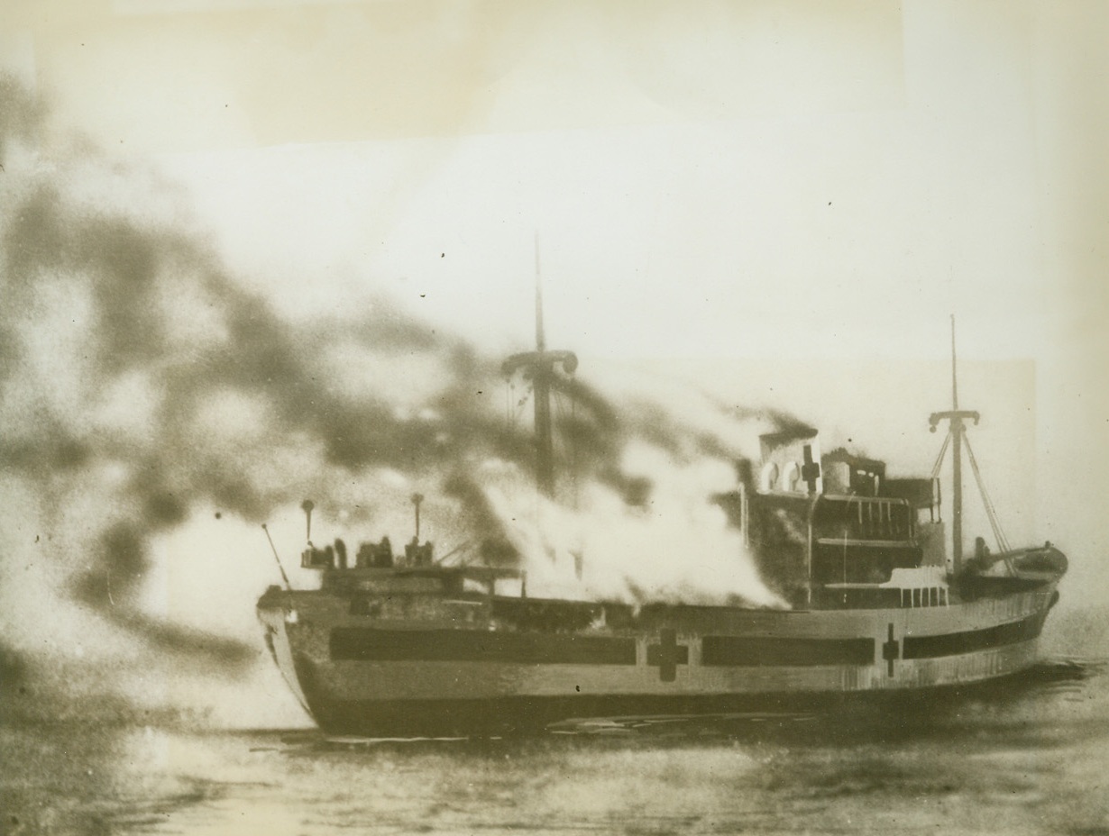 Red Cross Glows ‘Neath Flame, 6/10/1943. A red cross glows from the side of the burning hospital ship, “Ramb IV,” visible now as it was when enemy aircraft bombed and sunk the vessel in the Mediterranean on May 10th. There were six hundred wounded soldiers aboard the mercy ship when she left Tobruk. Originally an Italian hospital ship, the “Ramb IV” was detained in 1941 for use by British and enemy wound. Photo was made by one of the survivors. Credit Line (Acme);