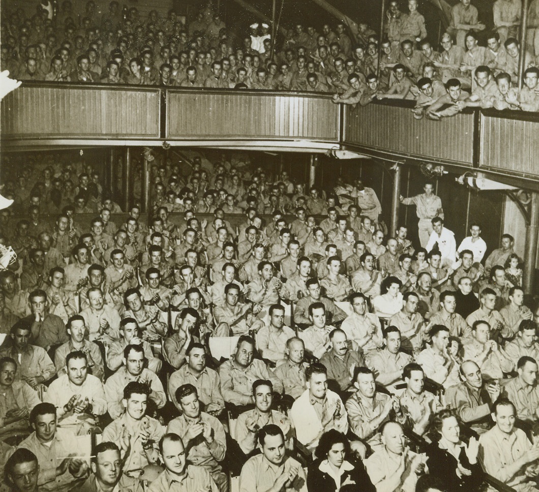 Scandal in the South Seas #3, 6/27/1943. South Sea Island Base – There’s not a sober face in the lot, as service men and guests cheer a number in the “South Sea Island Scandals.” Five lovely fighting French civilian girls were added attractions in the peppy review put on at a South Sea Island Base.Credit: ACME;