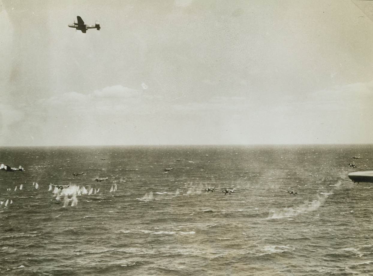 U.S. Fighters Shoot Down 25 Axis Planes, 6/4/1943. Axis planes are riddled by machine gun fire during the recent attack when a formation of U.S. Army Air Forces B-25 Mitchell Bombers and an escort of P-38 Lightnings engaged an Axis air convoy of 35 planes over the Sicilian Straits. Twenty-five of the enemy planes were shot down. Two American planes are shown in this photo. The one at the extreme left, flying low, has just completed attack action while another B-25 is shown overhead. Twelve Axis air transports, almost at water level, are under attack in this view. Credit: U.S. Army Air Force photo from ACME;