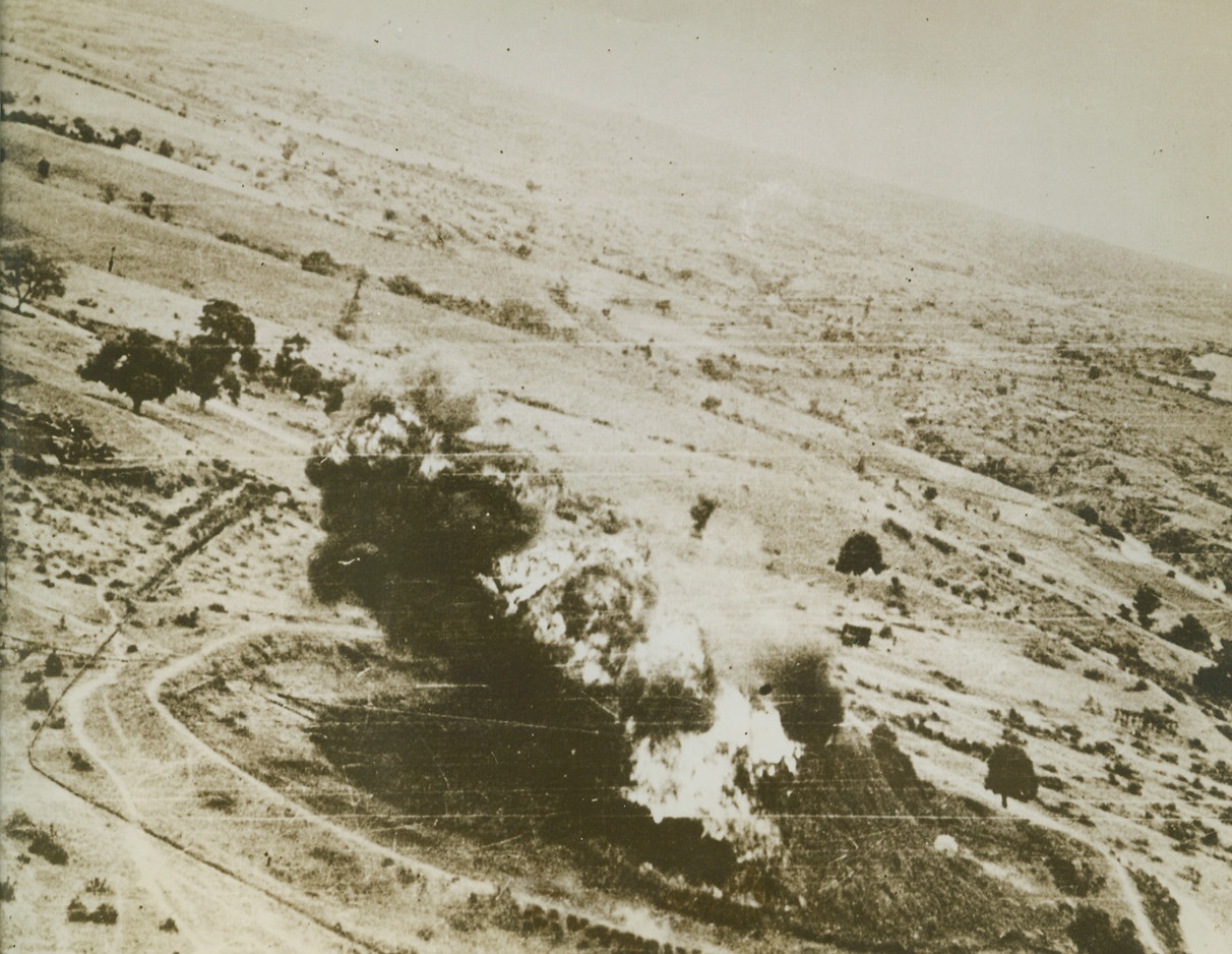 “HILL” GOES UP IN FLAME, 8/31/1943. YONANGYAUNG, BURMA—Cleverly camouflaged to look like a ill, this Jap oil storage tank at Sadaing Tank Farm, just south of Yonangyaung, goes up in roaring flames—failing to fool Beaufighters of the RAF during a recent raid. Five storage tanks stood on this site originally. Four were destroyed by the British on evacuation, but the fifth was only damaged. The Japs repaired the tank, filled it with a million gallons of oil from neighboring wells, camouflaged the tank, and got a nice, warm fire for their trouble. Credit: Acme;