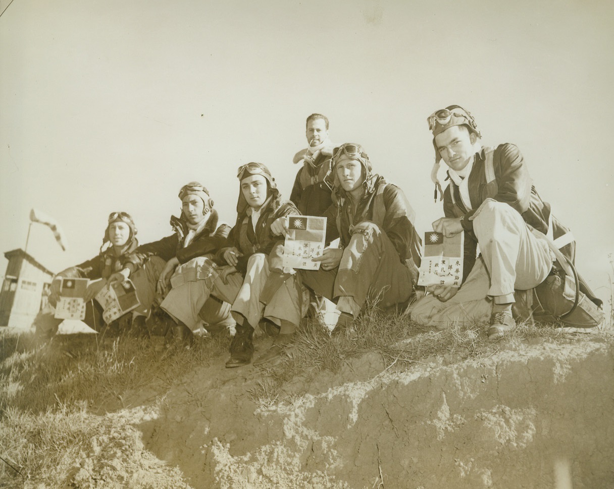 Ticket Home, 1/13/1943. Somewhere in China – American fliers in China display flags issued by the Chinese government which insure assistance and safe return to an American base if they should be forced down.  Left to right, seated: Lt. T.J. Clark, Pennsylvania; Lt. W.A. Smith, Oklahoma; Lt. R.W. Lucia, New York; Lt. J.M. Williams, Texas; lt. R.P. Atkinson, West Virginia; standing, Capt. C.L. Blair, Michigan. Credit line (ACME);