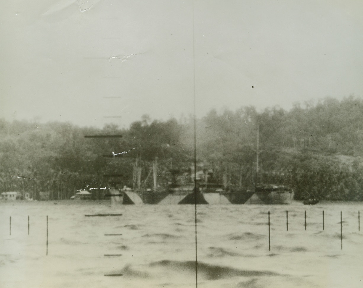 American Submarines Attack Jap Shipping, 1/23/1943. An unsuspecting Japanese merchantman of more than 9,000 gross tons lies in an unidentified Pacific harbor unaware of the U.S. submarine from which this daring picture was snapped.  Note the small boat pulling away from the camouflaged vessel.  Shortly after this picture was made American torpedoes found their mark on this vessel which was close to shore. Credit line (US Navy official photo from ACME);