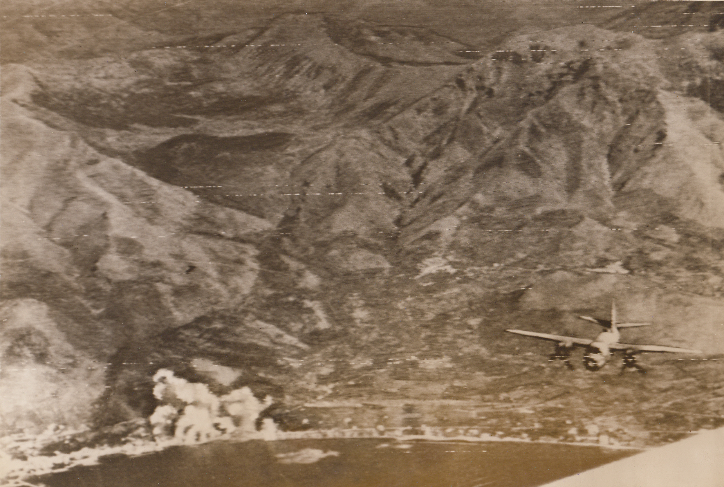 Yanks Bomb Rome-Naples Highway, 9/23/1943. In this photo, flashed to the U.S. by Radiotelephoto today, a Martin B-26 Marauder, (lower, left), of the U.S. Army Air Forces, can be seen swinging away from its bomb run, while its bombs burst on the target, (lower, left in photo), a vital junction of the Rome-Naples Highway. It is precision bombing such as this that is helping the Allies to close in on Naples. Today, British and American troops are within sight and sound of that city, which the Germans are preparing to abandon.;