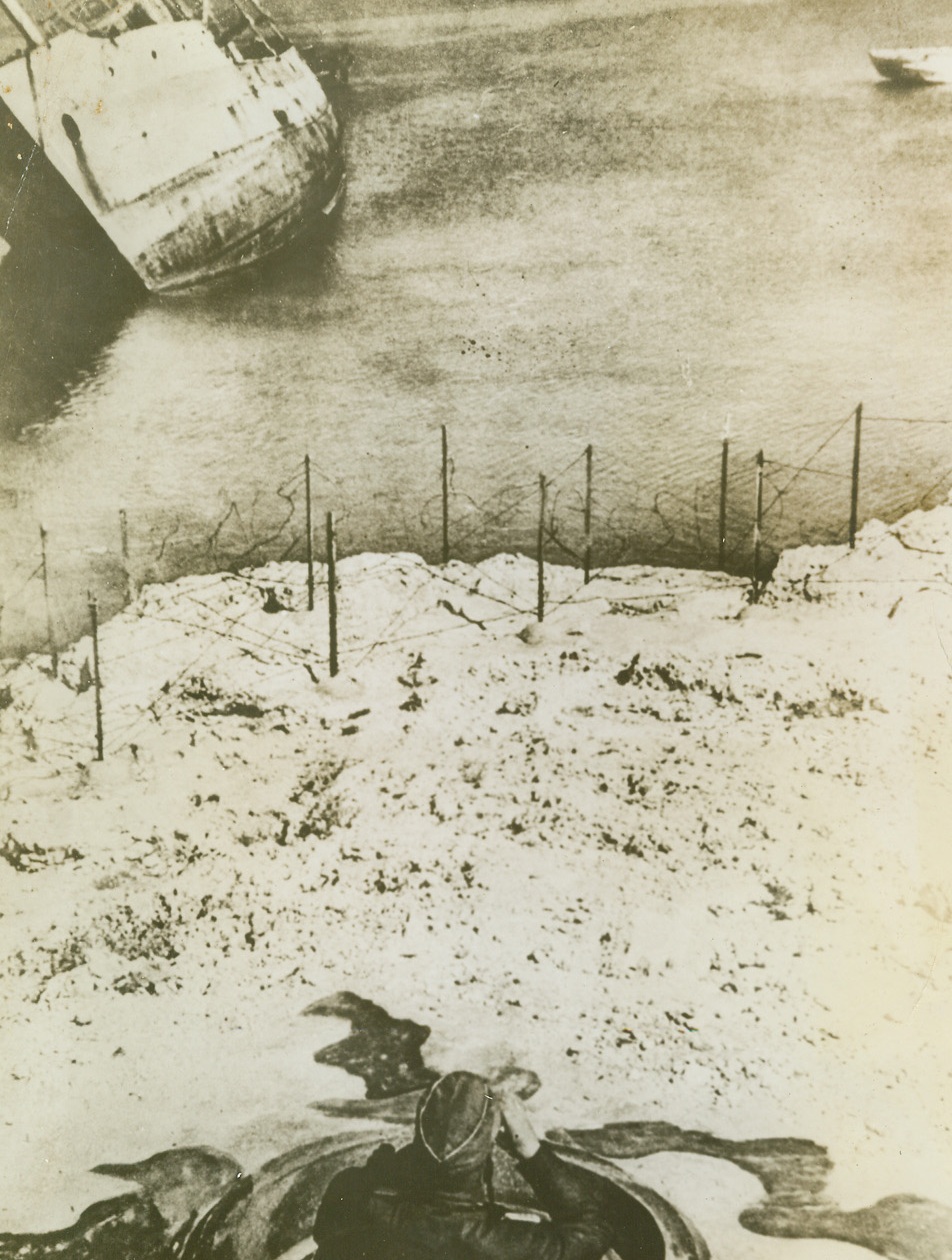 Watching for Allies’ Next Invasion?, 9/30/1943. This photo from a neutral source, shows a German soldier, (lower, center), with a pair of field glasses looking out to sea from an observation post on the Nazi-occupied island of Crete. With the location of huge Allied forces in the Mediterranean still un-announced, the Nazis in sections not yet invaded in this area, are suffering a severe case of “invasion jitters.” The Germans call observation posts such as this one, (photo above), “Tobrukstands” – probably named for the city in North Africa where Rommel’s Afrika Korps “should have stood”.Credit Line (Acme);