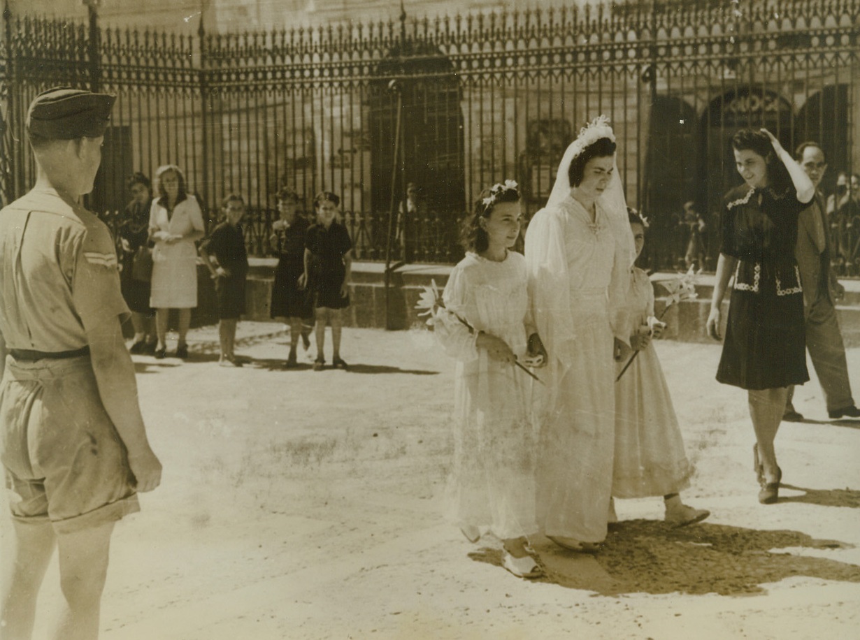 Here Comes a Peacetime Bride, 9/12/1943. Sicily – The war is over in Sicily, and a native bride arrives at the church with her attendants. The wedding in Lentini is watched by an R.A.F. driver, Corp. G. Hennah, of London. Life has resumed its normal flow in Sicilian towns occupied by the Allies, and civilians who fled the battle zones are back in their homes with their neighboring farms once again harvesting crops. Credit: ACME;