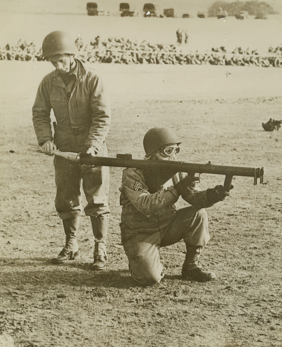 First Photos of Firing of “Bazooka”, 9/13/1943. Washington, D.C.—This is one of the first photos to be released by the War Department of the firing of the U.S. Army’s new rocket gun, popularly known as the “bazooka” and officially listed as “Launcher, Rocket, AT, W-1. The gun has proven very effective against tanks, can be carried by foot soldiers and be used in places inaccessible to large anti-tank guns. Here, one soldier holds the “bazooka” on his shoulder, while another man loads it with a rocket.  Credit: US Signal Corps Photo from ACME.;