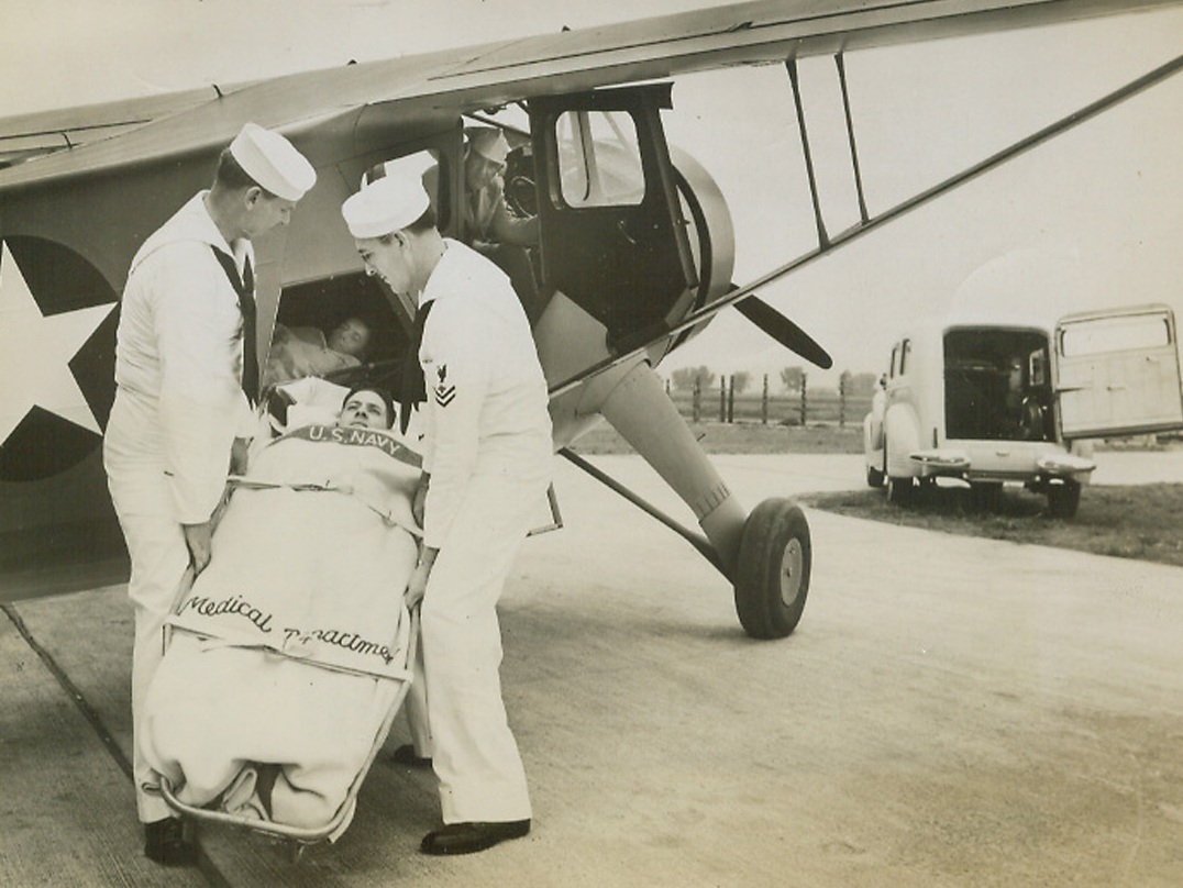 Rehearsal for Mercy, 9/12/1943. Chicago—Navy men from Chicago try out the new naval hospital ship, the Howard Nightingale, first of a new type of swift, maneuverable plane being turned out to transport badly wounded men from battle fronts to hospitals behind the lines. The plane holds two wire basket-type stretchers, one above the other, in a rigid position so that manipulation of the plane while dodging possible enemy pursuit will not further injure the patients. Naval officials and the Howard Aircraft Company, manufacturers of the ship, are dedicating it to Florence Nightingale. Photo No. 2 is a close-up of the plane as a stretcher is placed in it.(passed for publication).Credit: ACME.;