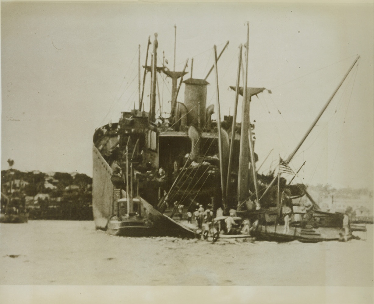 THE SHIP THAT WOULDN’T SINK, 10/28/1943. Decks awash, steering gear out of commission, and with an enemy torpedo ripped through two bulkheads this Liberty ship arrived at a South Pacific port under half speed, with the aid of another ship. She was carrying war material to U.S. Forces in the South Pacific when the torpedo made a direct hit in her side disabling her steering gear. Capt. M. Freeman held part of the crew aboard to fight fire and protect cargo while the remainder took to boats to insure against loss of life. Seventy-two hours after being hit she began the voyage to port which was made in eleven hours. No loss of life occurred. Credit: U.S. Navy photo via OWI Radiophoto from ACME;