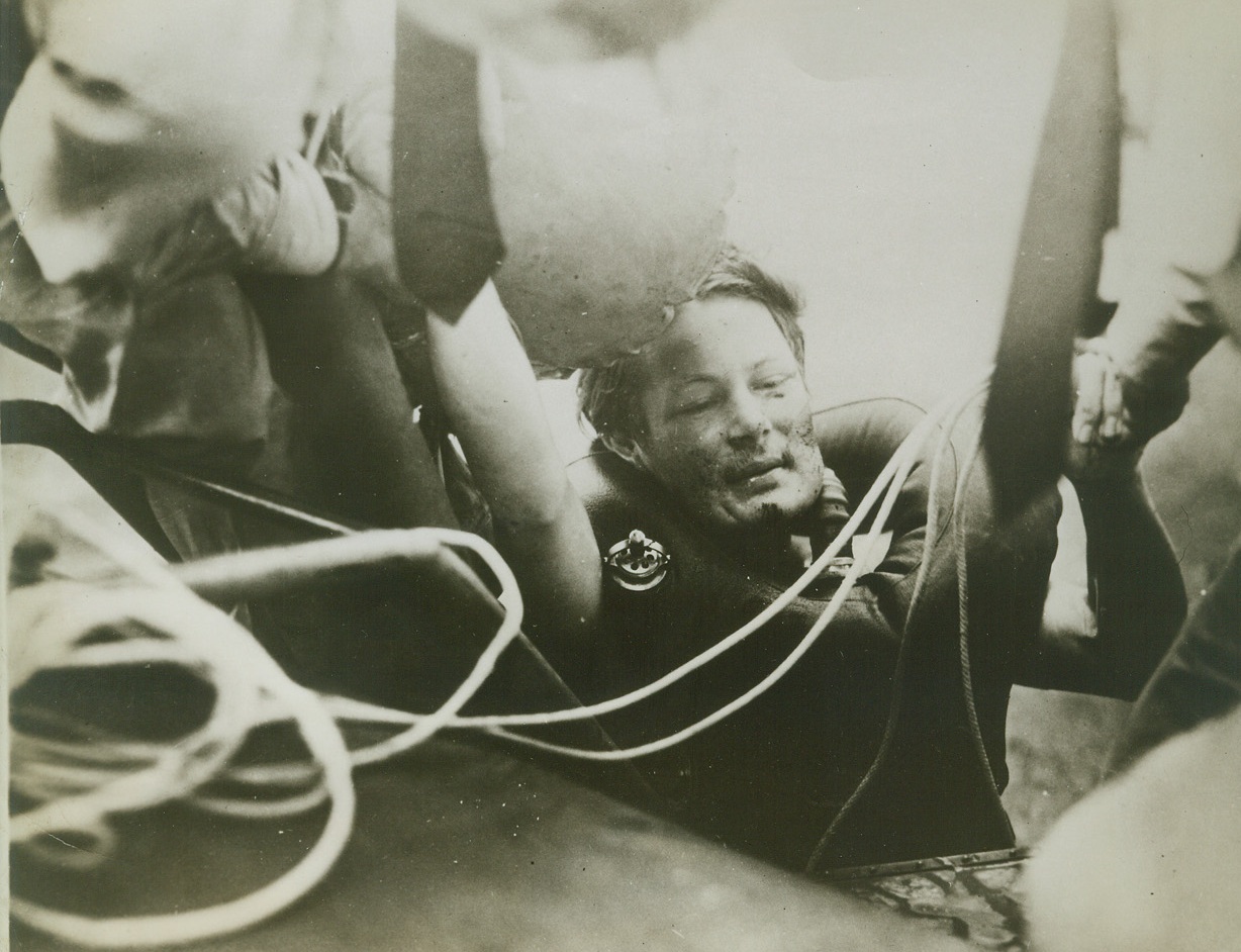 COAST GUARD RESCUES GERMAN U-BOATMAN, 10/20/1943. WASHINGTON, D.C.—A German submarine man, one of seven rescued, is hauled up a pontoon of the Coast Guard plane that rescued him. He wears an escape lung. For this rescue, and for successfully performing other dangerous flight missions, the Distinguished Flying Cross was awarded to Commander Richard L. Burke of the Coast Guard by Navy Secretary Frank Knox. Credit: U.S. Coast Guard photo from Acme;