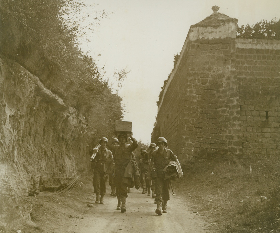 ANSWERING THEIR BUDDIES’ S.O.S, 10/24/1943. ITALY—Medical aid men move forward on the double to a company covering the Volturno River bank where their help is urgently needed. The battle for that water defense line is being waged a short distance away. Credit: Acme photo by Bert Brandt, War Pool photographer;