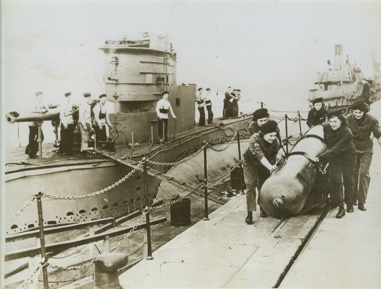 Fighting Girls of the Royal Navy, 11/23/1943. England – Cheered on by the crew of a British sub, pretty, hard-working Wrens wheel out a tin fish for a submarine that is soon to go on patrol. By working on torpedo maintenance, the British Navy women release many fighting men formerly tied to bench and workshop jobs.  Credit: (ACME);