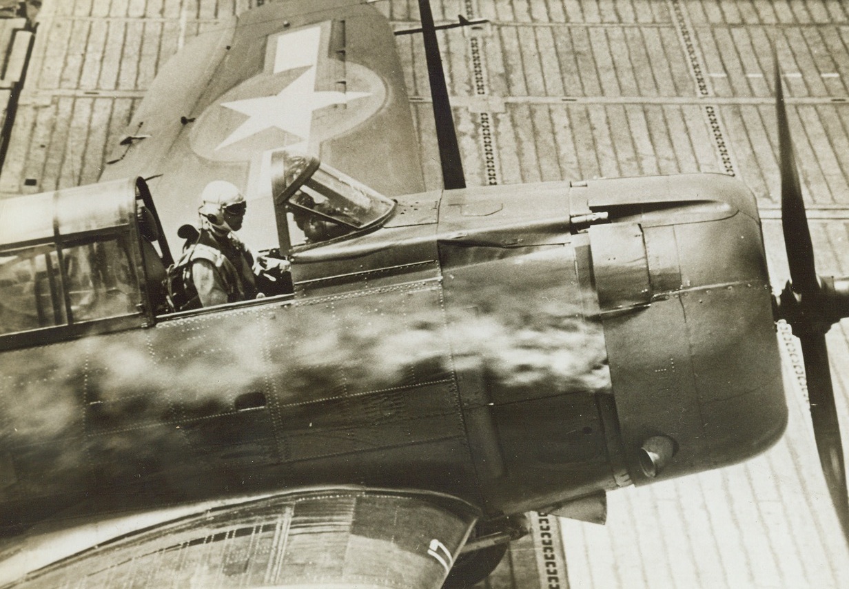 Nick of Time, 11/26/1943. South Pacific – His engine blazing from a lucky Jap hit, an American pilot brings down his Dive Bomber on the deck of a U.S. Aircraft Carrier during the raid on Rabaul when we knocked 70 Nipponese planes out of a flaming sky and sank 13 destroyers. Rather than bail out, this pilot outwitted the pursuing enemy and managed to bring down his plane. Credit: ACME;