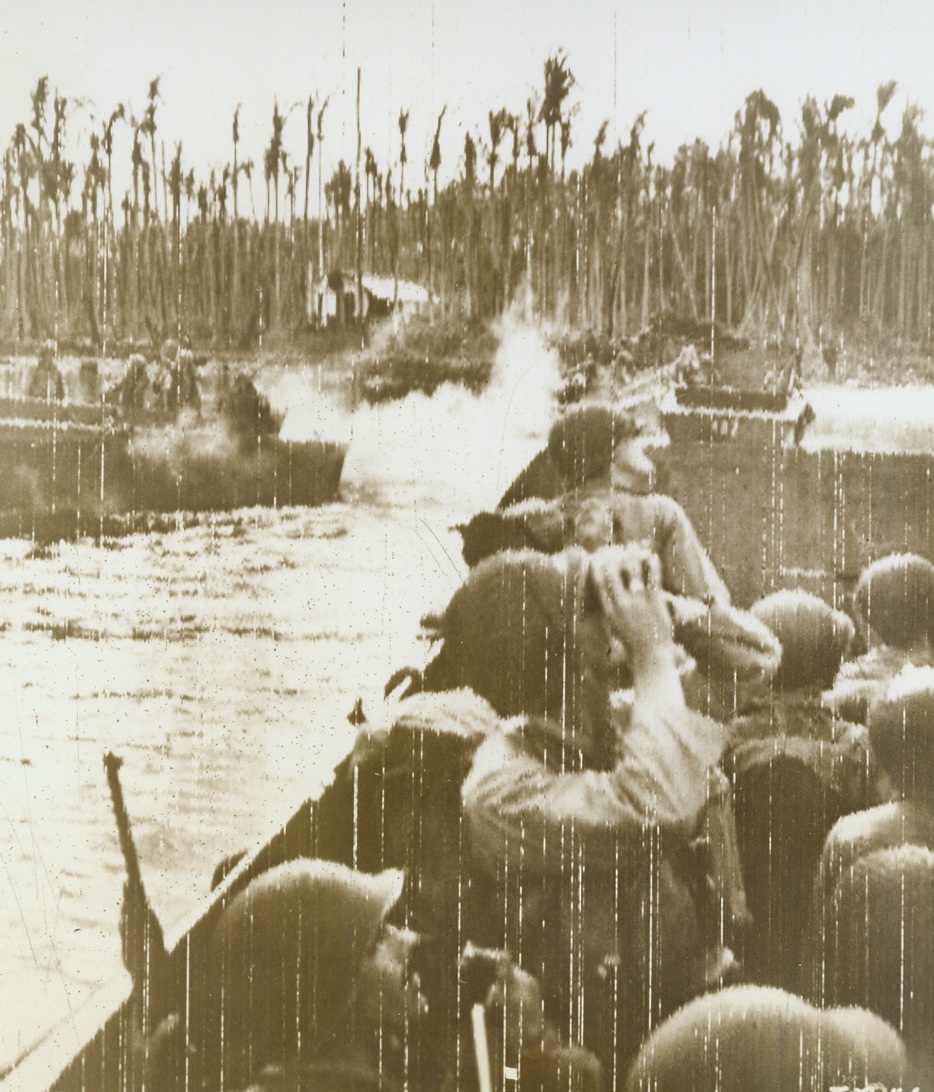 YANKS LAND ON NEW BRITAIN, 12/18/1943. ARAWE, NEW BRITAIN—As their LCV skims over Pacific waters toward the shore of Arawe, Yanks anxiously scan the skies, watching the approach of enemy planes. Invading New Britain under heavy bombing and staffing from Japanese planes, our troops escaped with light casualties, losing only two LCV’s in the important operation. Credit: U.S. Signal Corps radio from Acme;