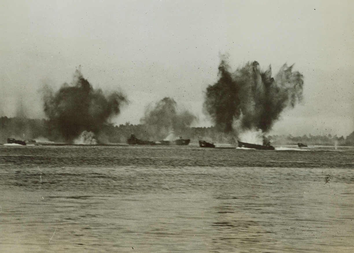 Japs Bomb Arawe Invaders, 12/31/1943. Arawe, New Britain – Great geysers of black smoke and spray rise from the water around a group of LCT’s as Japanese bombs rain down upon the invaders at Arawe, New Britain. Photo was made at the height of the Allied invasion on that Jap stronghold. Credit: ACME;