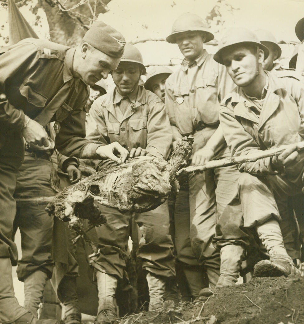 As Moroccans Prepared to Battle Germans, 12/28/1943. Italy – It has now been revealed that Mohammedan troops from French Morocco have entered the Allied Fifth Army lines and are actively engaging the Germans in the mountains northwest of Venafro, with excellent results. Before these troops moved into battle, and while they were encamped in the plains to the rear of the Fifth Army lines, the Mohammedan soldiers observed their Ait Kebir, or Great Feast, a solemn religious ceremony which marks the arrival of the new year (it is now the year 1364 on their calendar.) With preparations for ballet under way, uniforms were substituted for the usual colorful costumes, and the usually violent tribal dancing was dispensed with. Instead one of the solders performed a brief token dance. In Morocco it is the custom during the feast that every married man kill a sheep, which is then roasted whole and eaten with a sort of bread cake made of coarsely ground wheat and streamed above a caldron of boiling vegetable stew. In spite of wartime scarcity of the animals in Italy, the soldiers had plenty on hand for the feast, getting them in various mysterious ways about which officials were a bit vague when asked. In this series of photos, taken by Acme photographer Bert Brandt, various parts of the Ait Kebir are shown. (Passed by Censors). Major Jacques Allard, (left), Commandant of the French Regiment, puts his “seal of approval” on the feast by tasting a bit from one of the roasted sheep. Credit: ACME photo by Bert Brandt for the War Picture Po;