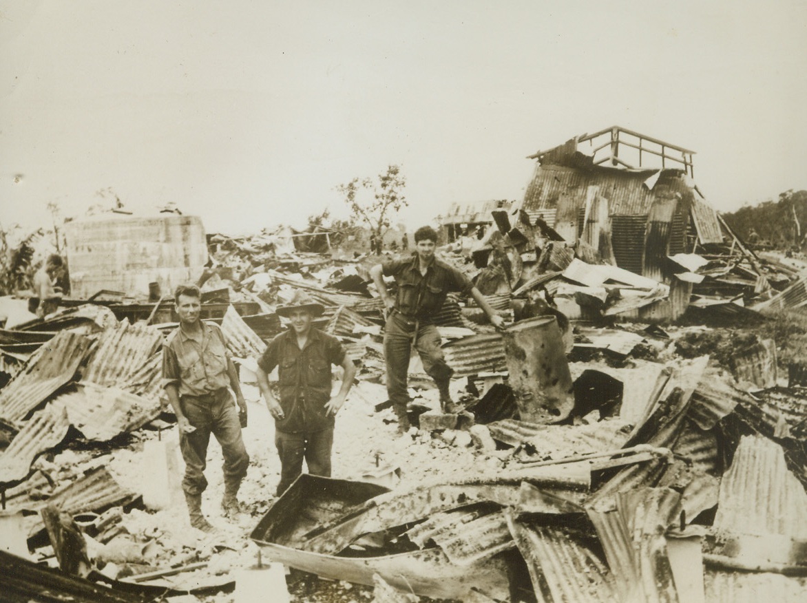 BIG GUN SHARP-SHOOTERS, 12/23/1943. NEW GUINEA—Australian fighters get eye-witness proof of their artillery and bombing accuracy, as they inspect Satelberg, village on New Guinea recently wrested from the Japs. Before seizing the enemy base, the Aussies subjected it to a terrific pounding from air and land.Credit: ACME.;