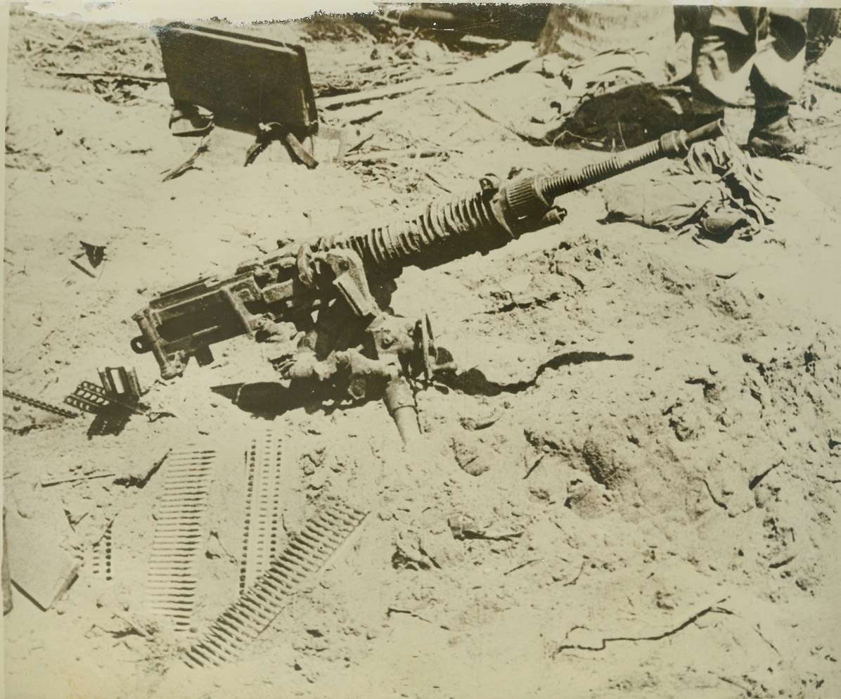 JAP MACHINE GUN CAPTURED IN SOLOMON AREA, 10/21/1942. This photo, which has just been released and which is from an official U.S. Marine Corps newsreel, shows a captured Japanese machine gun, covered with sand and with its ammunition strewn about on the ground. It was apparently dropped in haste as U.S. forces attacked the gun placement during recent heavy fighting in the Solomon Islands battle area. Credit: U.S. Marine Corps photo from ACME;