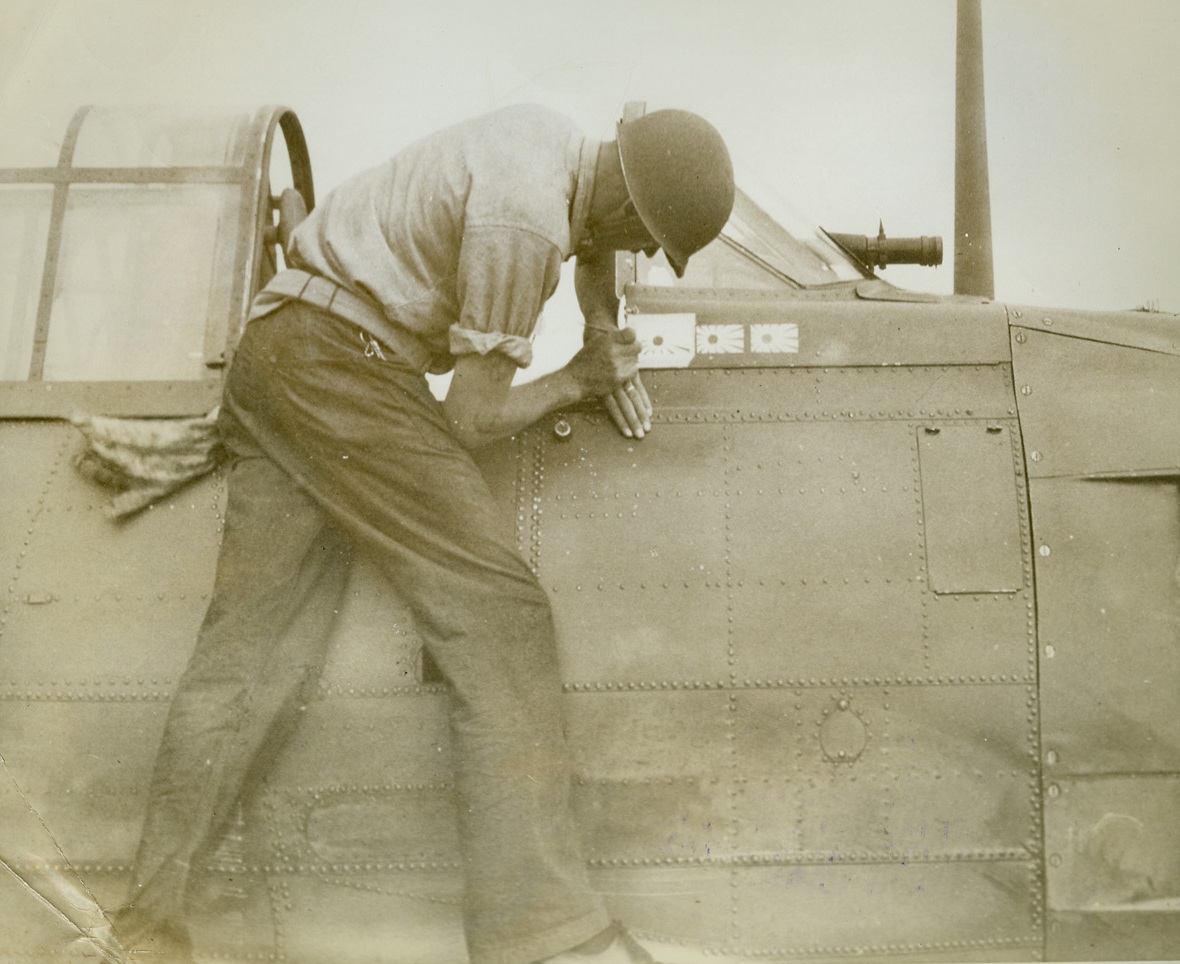 Another Jap “Notch” for This Fighter, 10/22/1942. A sailor aboard one of Uncle Sam’s aircraft carriers adds a third tiny rising sun flag to the “scoreboard” on the cowling of a U.S. Navy fighter plane, signifying that it’s guns have blasted three Jap planes out of the skies and sent their crews to their “Hon. Ancestors.”  This photo was released by the Navy Department in Washington, today.Credit Line (U.S. Navy photo from ACME);