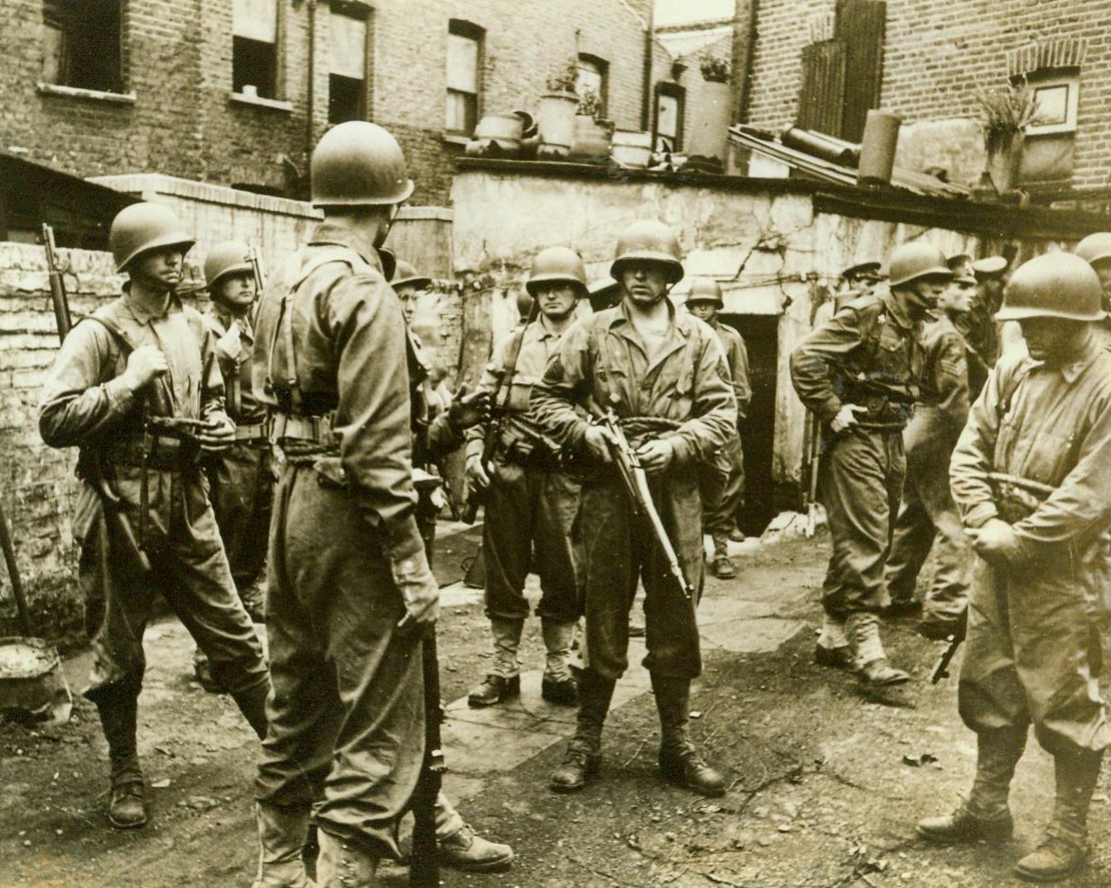 Eighteen officers and six sergeants, 10/8/1942. Eighteen officers and six sergeants of the U.S. Ranger troops wait for the command to move down the theoretically sniper-infested “course.” At the military equivalent of the word “Go,” the special detachment will practice house-to-house invasion tactics, blasting the enemy and taking the specialized inch-by-inch offensive. CREDIT LINE (ACME) 10/8/42;