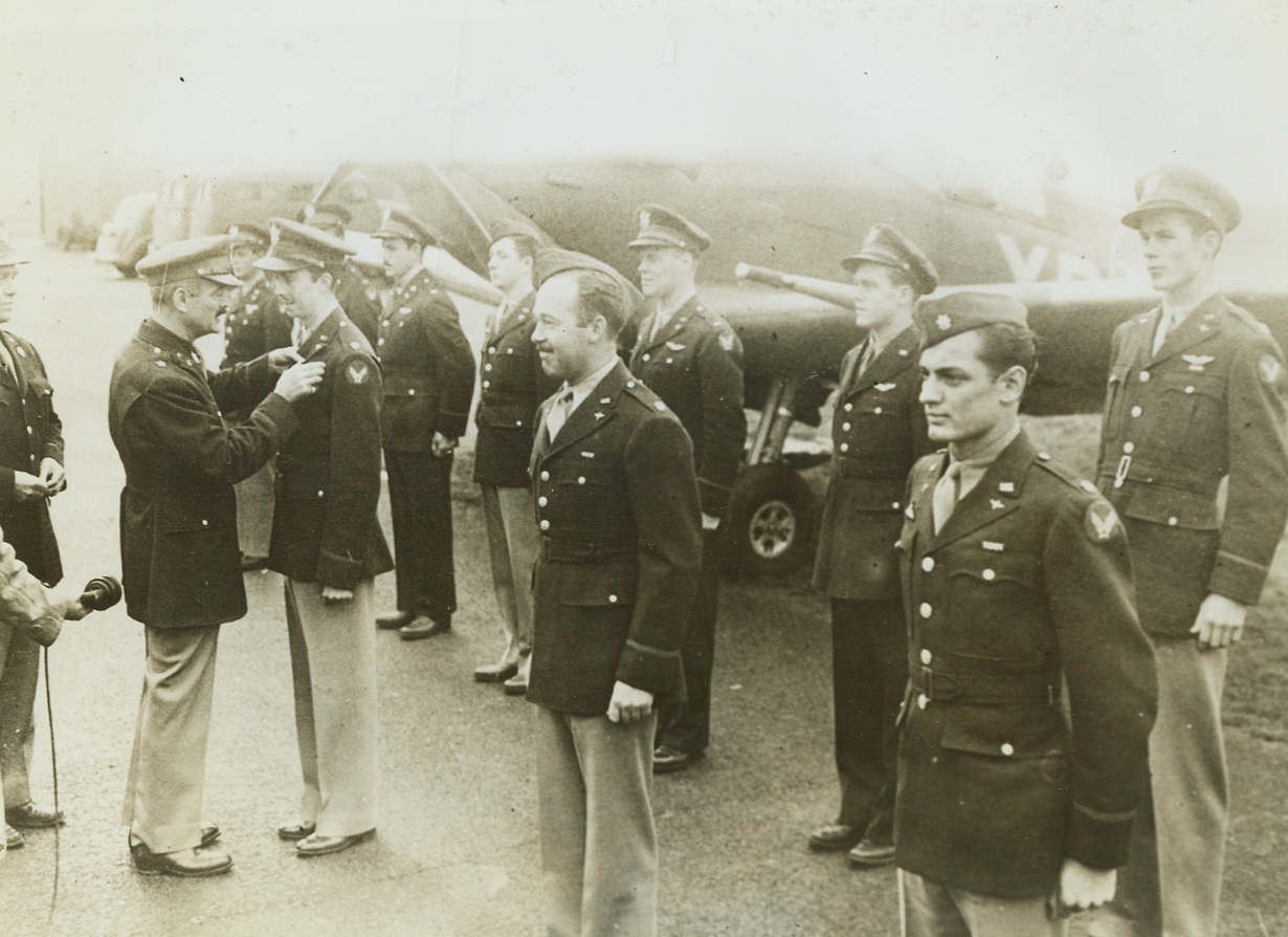 “Eagles” Get Second Pairs of Wings, 10/10/1942. Britain – Brig. Gen. Hunter, commander of the Fighter Command of the U.S. Army Air Forces in Britain, pins a pair of U.S. Air Force wings on Maj. G.A. Daymond of Burbank, California, famed U.S. ace of the RAF’s American Eagle Squadron and holder of the Distinguished Flying Cross and Bar, during a ceremony in which the Eagle Squadron was transferred to the U.S. Army Air Force. Other “Eagles” in front row are Maj. C.W. McColpin, of Buffalo, New York, and Maj. W.J. Daley, DFC, of Amarillo, Texas. Passed by Army censor. Credit: ACME;