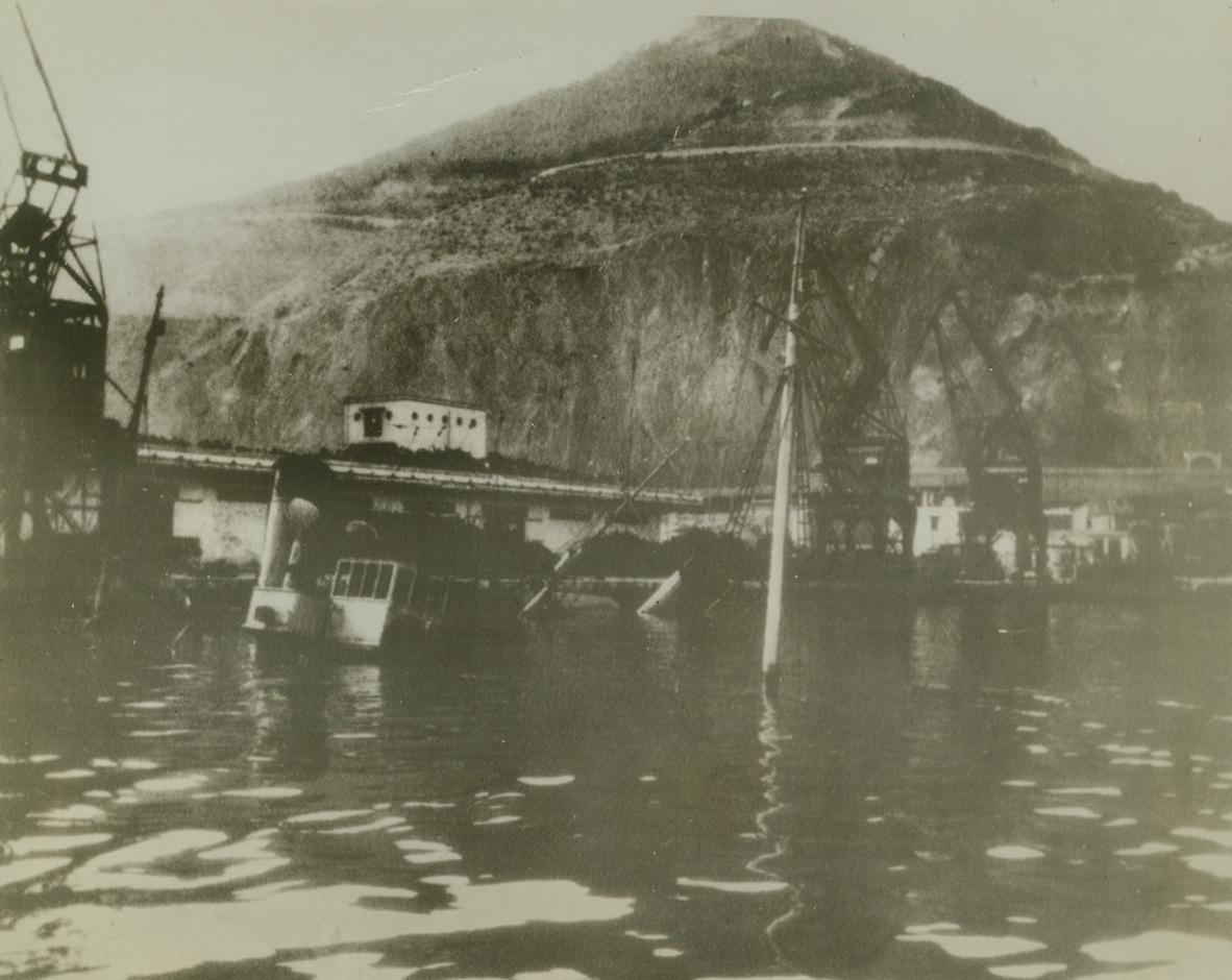 Price Paid, 11/28/1942. Oran, Algeria—With only their masts and funnels showing over the waters of Oran Harbor, these two sunken French ships are part of the price paid by the French when they attempted to bottleneck Oran Harbor before the fall of North Africa to the A.E.F. Six ships were scuttled here and fourteen more were destroyed further inside the harbor. Photo was radioed from London today. Passed by censor. Credit: ACME.;