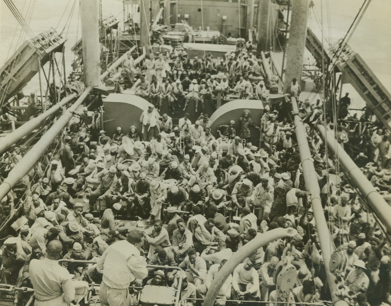 American Troops Arrive in Liberia, 12/3/1942. Monrovia, Liberia—President Edwin Barclay of Liberia today announced the arrival last June 17th of U.S. troops in this strategically-located country, which is located 700 miles south of Dakar, on the west African coast. The Americans, negro soldiers with white officers, will protect—with the consent of the Liberian government—this tiny republic which is considered a vital spot in the trans-African lifeline of the United Nations. It is regarded as an important base for air operations in Africa and the western part of the South Atlantic. An agreement between the United States and Liberia allowing the occupation, was concluded last March 31st. In this series of photos, released by the war department in Washington today, the U.S. troops are shown aboard a transport just before they arrived in Liberia. New York BureauAs the transport flows steadily through bug-infested waters, Chaplain J.R.C. Pinn (in immediate foreground with back to camera, right), conducts Sunday services on the forward deck. Every available spot is filled.Credit: U.S. Army photo from ACME;