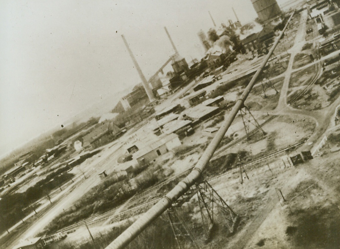 Boston Bombers Blast Dutch Works, 12/28/1942. Smoke wells up from the target area as the unescorted Boston Bombers that successfully attacked Nazi-controlled steel works in Holland fly away unharmed. The angle of the photo gives indication of how long the American made planes in the R.A.F. Bomber Command were flying in the daring daylight attack. It looks like a direct hit on the tanks of the Benzol by-product plant at the Royal Dutch Blast Furnace and Steel Works at Velsen.Credit: ACME.;