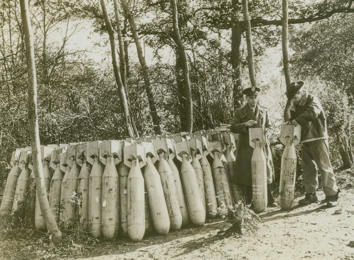 FIRST AMERICAN BOMBS IN ENGLAND, 12/11/1942. ENGLAND – The American air effort in England has progressed from U.S. pilots flying with the R.A.F., American bombers dropping British bombs, and finally American crews flying American bombers from their own stations in England to drop American-made bombs.  Here are some of the first 100 lb bombs being readied for their trip to the axis on “Liberators”.Credit: Acme;