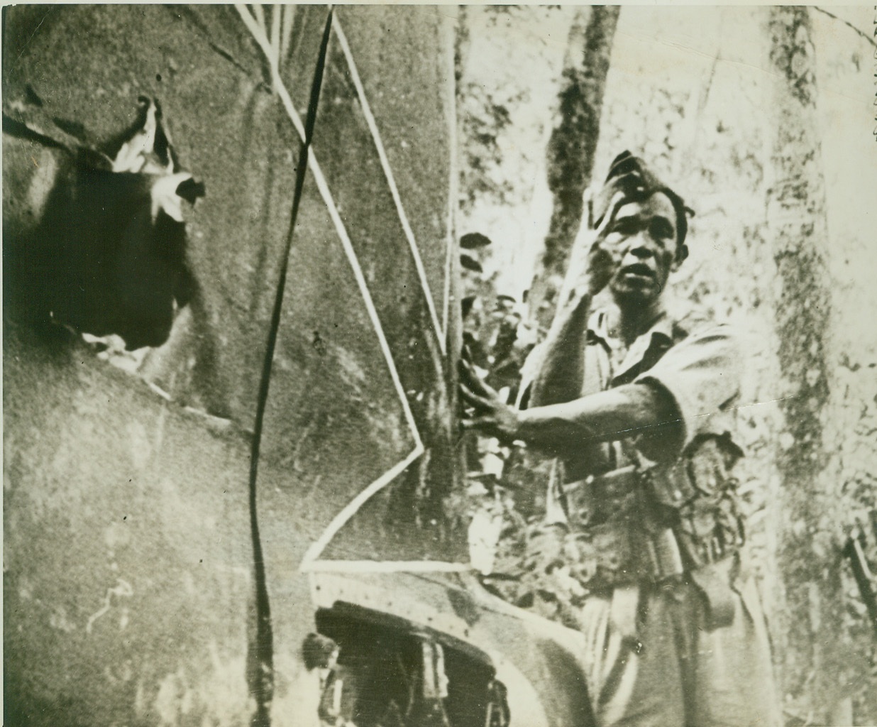 TAIL OF WRECKED JAPANESE AIRCRAFT, 2/8/1942. MALAYA – Tail of Japanese plane, shot down in Malaya by British anti-aircraft, shows the red arrow marking of Nippon aircraft. The rest of the aircraft, which received a direct hit, was scattered over a mountainside and the body of the pilot found a half-mile away, with his parachute unopened. (Passed by Censors.) Credit: ACME;