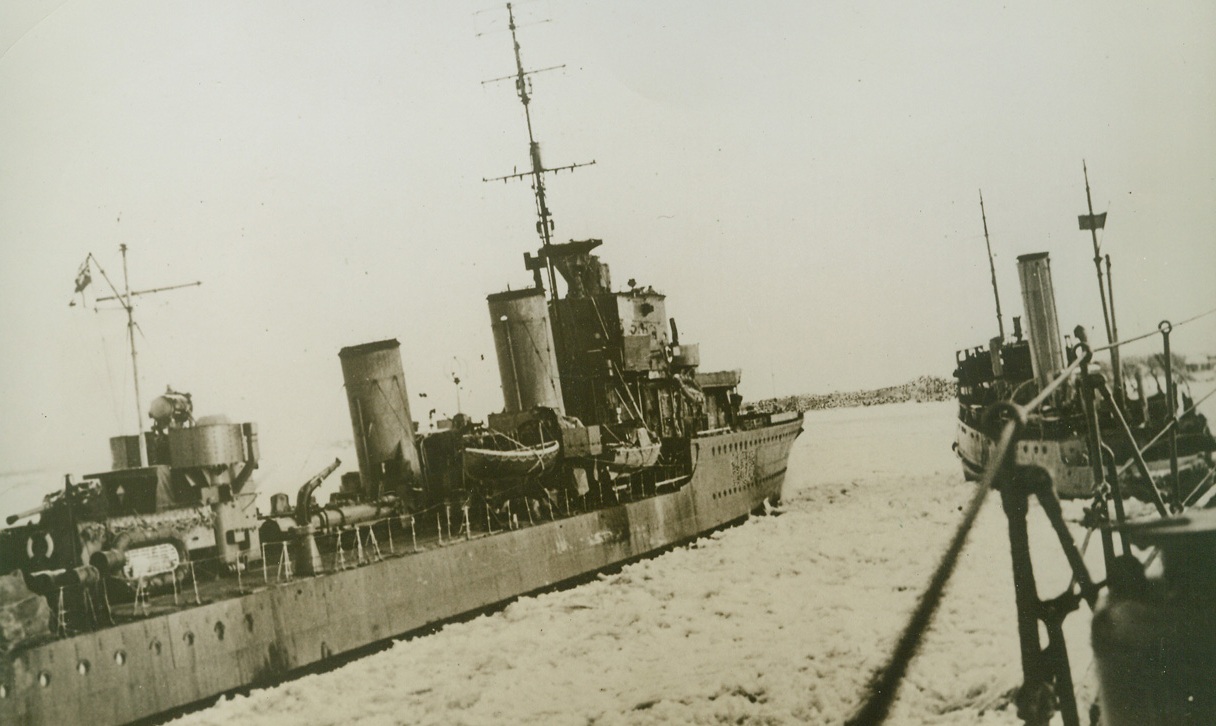 FRIGID GOING, 3/7/1942. Braving the extreme conditions of Arctic winter, a British convoy steams safely through ice-covered waters with supplies for the Soviet Union. A Russian tug is ready to pilot the ships safely into harbor. Credit: Acme;