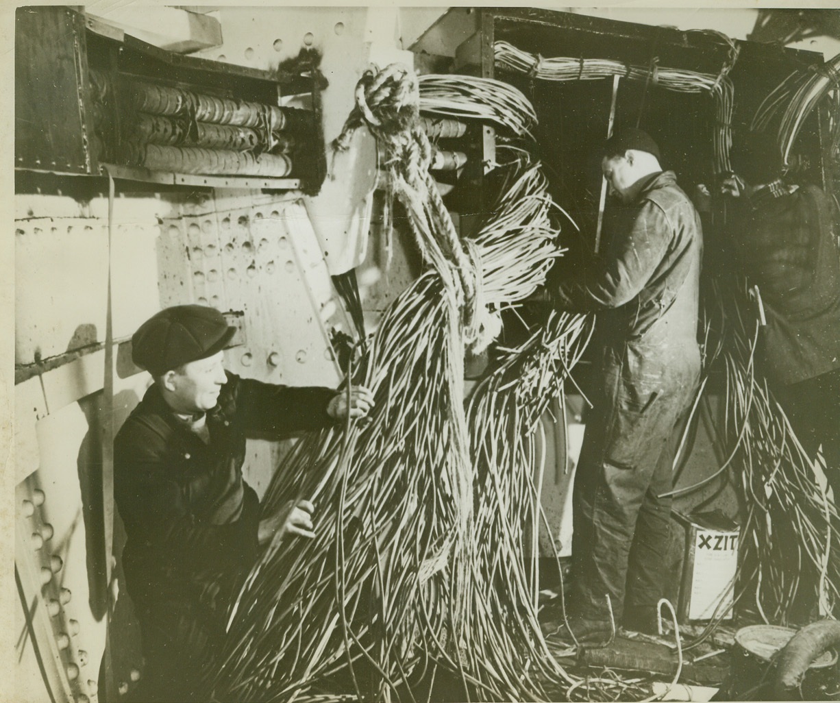 NAVY SPEEDS ARMING OF MERCHANTMEN, 4/9/1942. Shipyard workers, as they installed de-gaussing cables aboard a merchantman, to protect the ship against magnetic mines. Photo taking in shipyard “somewhere in the United States.” Credit: U.S. Navy photo via OWI Radiophoto from ACME;