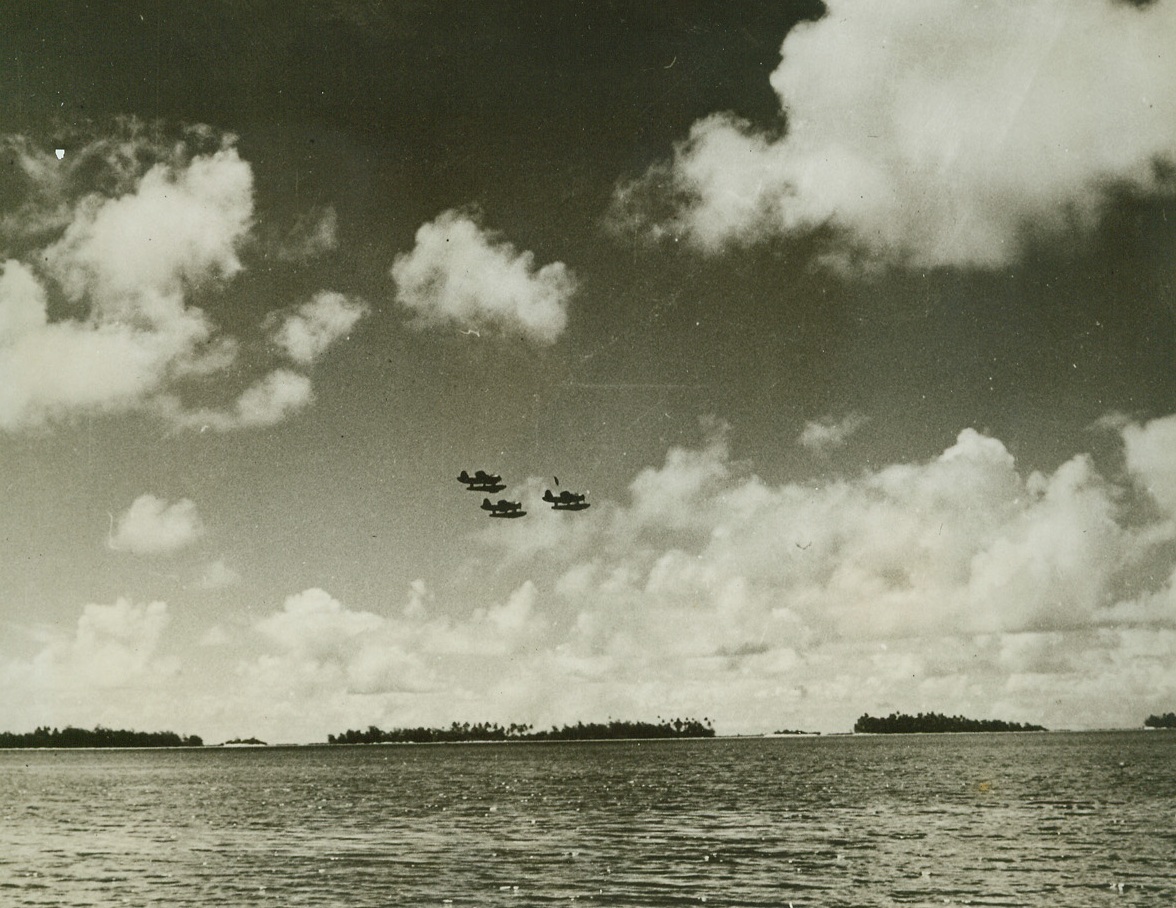 ESTABLISHING BASE ON SOUTH PACIFIC ISLE, 6/9/1942.SOMEWHERE IN THE SOUTH PACIFIC—The work required, the supplies necessary and the means by which Uncle Sam’s Army, Navy and Marine Corps move in on a South Pacific island to establish a new base is graphically illustrated in this series of photographs just released by the Navy Department. An officer and his advisers, up the runway ramps for seaplanes. Coral rock and sea urchins make the under-footing tough going. Credit: OFFICIAL U.S. NAVY PHOTO FROM ACME.;