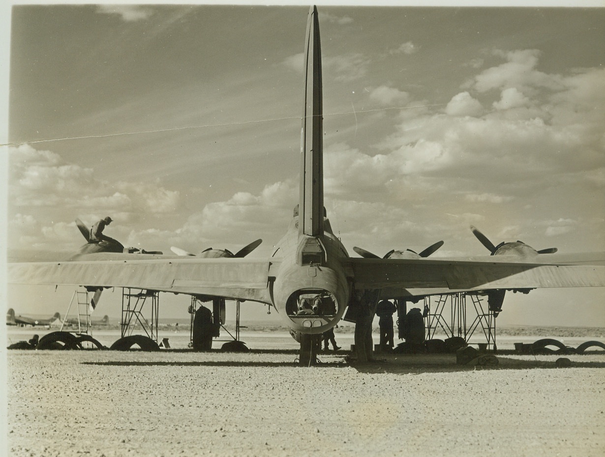 Stinger Close-Up, 7/26/1942. Here’s an unusual view of the tail end of a Boeing B-17F Flying Fortress, as mechanics check its four engines at an operational bombing base somewhere in the Northwest. the tail gun position is clearly seen. gunner sights through window just below rudder. Twin guns may be seen in extreme end of ship, with signal light below them. Credit: (ACME);