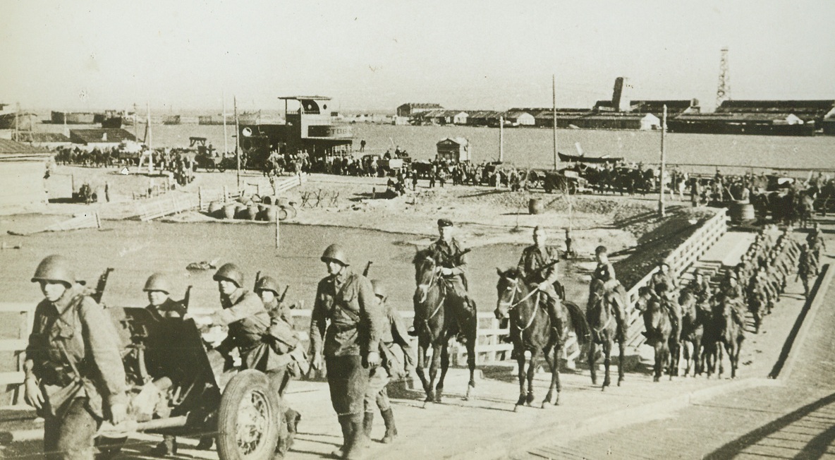 Reserves Move Towards Battle, 8/4/1942. Russia – A machine gun crew and mounted troops carrying sub-machine guns, part of a long line of Red Army Reserves, move up to the front, “somewhere in Russia.” (Passed by Censors).Credit: ACME;