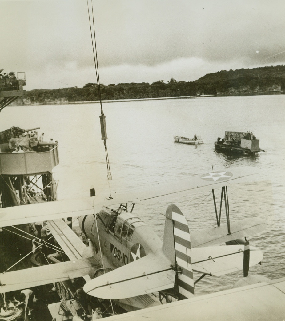 U.S. Supplies Land at Pacific Base, 8/13/1942. Crew members of a U.S. cruiser watch the operations as a landing lighter is towed ashore with tools and supplies for a U.S. built base in the Southwest Pacific.  The base affords the U.S. a jumping off base to counteract Japanese actions in the area. Credit Line (ACME);