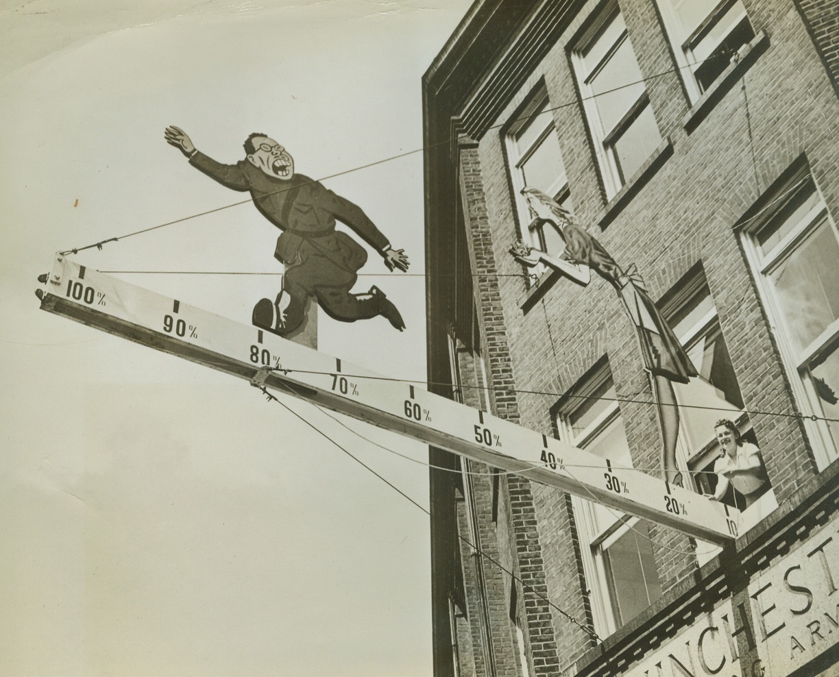 He Reached Our Goal, 8/27/1942. New Haven, Conn.—Helping the Jap on his way out is Helen Cherback, one of the thousands of employees at New Haven’s Winchester Repeating Arms Co. who signed up 100 per cent for war bonds. Helen is pushing the Jap to the 100 per cent mark as he flees from the handful of bullets held by a Winchester worker. The company is the largest plant in Connecticut to reach 100 per cent participation under the Treasury’s payroll deduction plan.Credit: ACME.;