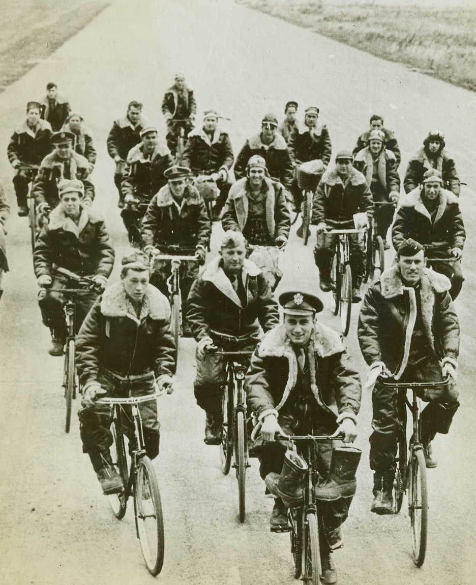 U.S. FLYERS WAIT FOR THE “ZERO HOUR”, 8/5/1942. SOMEWHERE IN BRITAIN – U.S. Army Air Force bomber crews, waiting along with many other American flyers, for the “zero hour” that will send them over Germany with thousands of tons of bombs, cycle across a huge air field to their planes for a flight, “somewhere in Britain.”  This is one of the first photos to reach the United States, of American operational bombing stations in Britain. Credit: Acme;