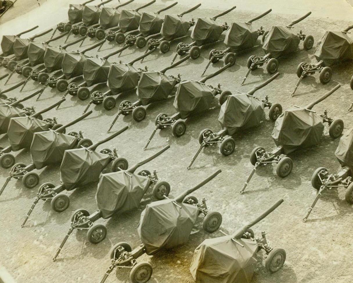 Big Bofors Anti-Aircraft Guns Ready To Smash Axis, 8/28/1942. Akron, Ohio -- Thirty and more a day of the big Bofors anti-aircraft guns roll off the assembly lines of Firestone Tire and Rubber Co., here as all-out production begins to really roll these guns in the direction of all fronts. Above photo shows a day's output lined up outside the plant. Guns were originally Swedish design. (ACME);