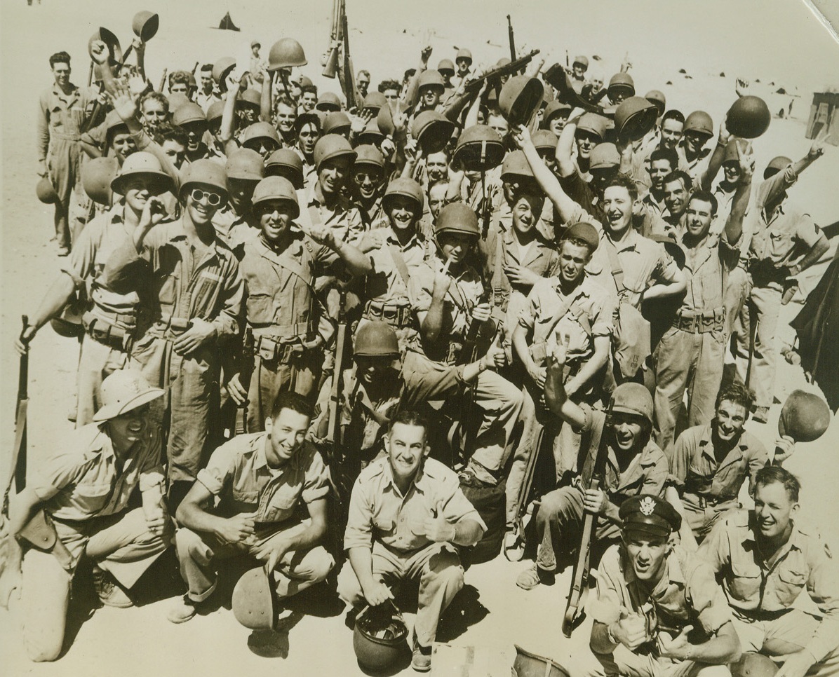 New U.S. Arrivals in Middle East, 9/12/1942. Middle East – It’s a toss-up between thumbs-up and V for victory signs with these newly arrived American troops somewhere in the Middle East. Here in their desert camp the boys are full of pep and smiles and rarin’ to go. Credit line (ACME);