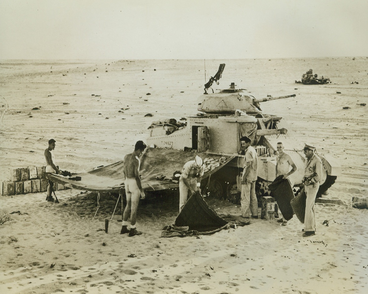 Bedding Down in the Desert, 9/11/1942. Egypt – Here’s how U.S. tankist park for the night in the Egyptian desert.  These two tank crews are a scant 3 ½ miles from the enemy lines.  Note that the two tanks are widely separated so that one bomb could not put both out of commission.  Men are unloading the tank and getting some of the sand out of their bedrolls.  For desert-style beds, see companion picture.Credit line (ACME);