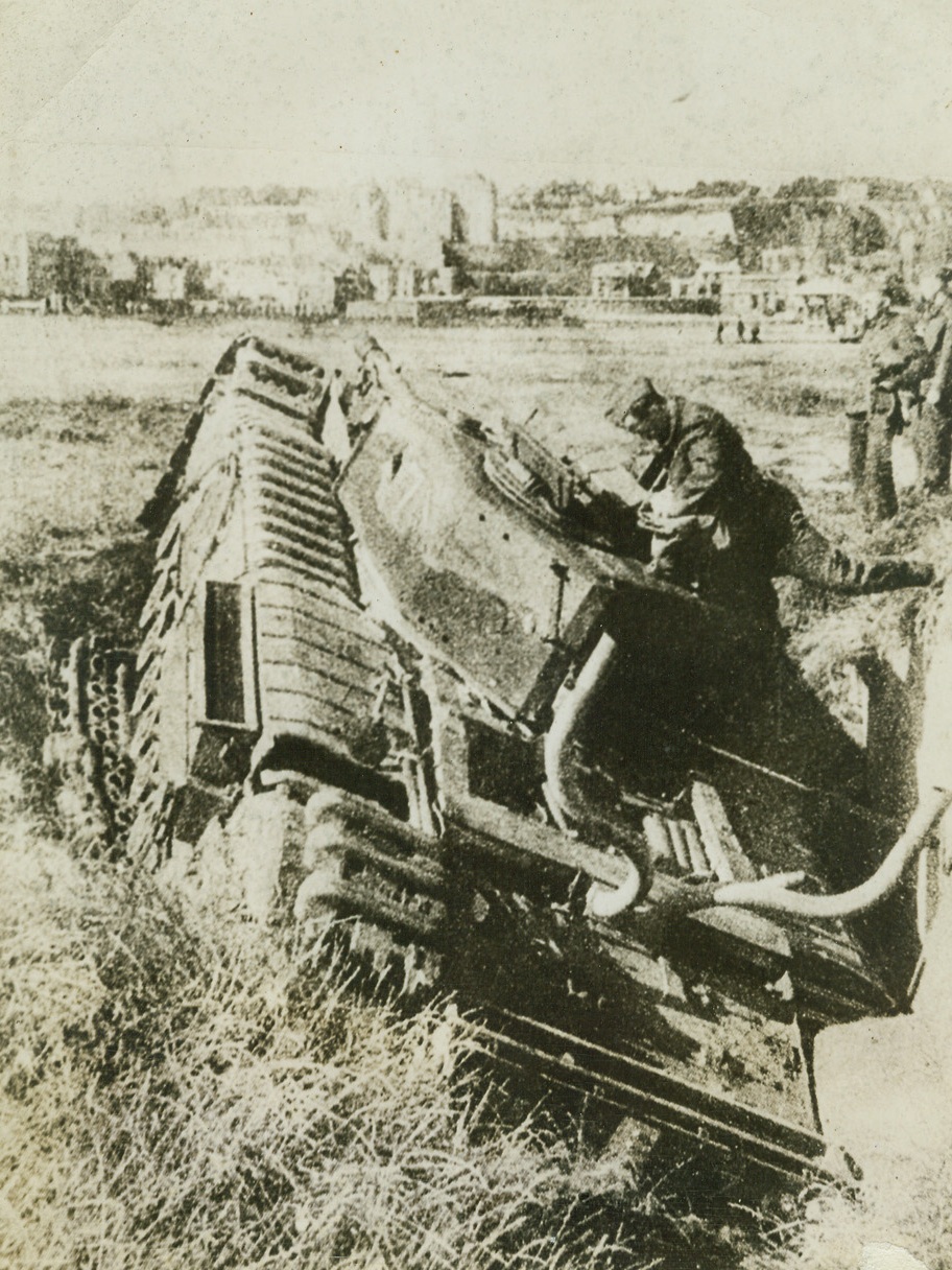 Tank Left at Dieppe Say Germans, 9/10/1942. Dieppe, France – According to the original caption on this photo, which was received in London from enemy sources, Nazi soldiers are examining a ditched Allied tank, which was damaged and left behind by Commandos during the Dieppe raid. Photo has just arrived in New York by Clipper. Credit: ACME;