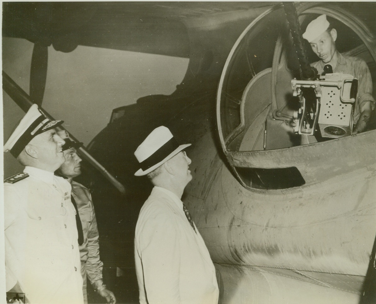 Secretary Knox Talks to Sub Hunter, 9/29/1942. Carribean Defense Area—On his tour of Carribean defense outposts, Secretary of the Navy Frank Knox, (center), talks to gunner Harry Suckman, (right), of Boston, Mass., still at his post in the gun blister of a PBY patrol plane after it returned to its base near the Panama Canal from a sub-hunting patrol flight. At far left is Rear Admiral Clifford Evans Van Hook, commander of the naval forces in the area.  Credit: ACME;