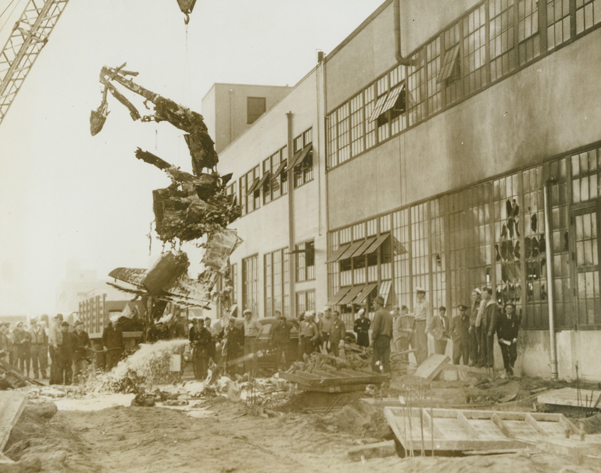 But the Pilot Escaped, 1/22/1944. San Francisco -- All that was left of Lt. Harry E. Paper’s single-seater Army fighter plane dangles from a crane at the Alameda, California, Naval Air Station where the aircraft crashed. Exploding, the cracked-up plane injured ten building employees with a shower of flaming gasoline, while the pilot parachuted to safety. Credit: U.S. Navy photo from ACME;