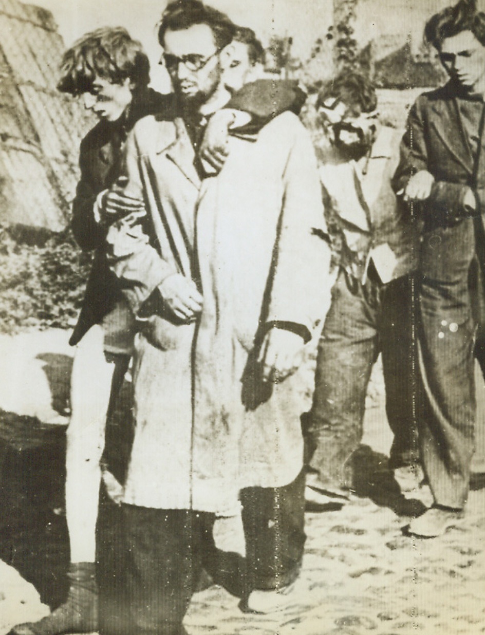 WARSAW POLES SURRENDER, 10/25/1944. Radioed to London from a neutral source and just received in New York this photo shows wounded and half naked men of the Warsaw resistance army marching dejectedly through the ruined streets of the Polish capital after their surrender to Nazi occupation forces. Premature uprising in Warsaw was quelled when the Russian armies bogged down on the outskirts of the city. Credit: Acme;